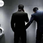 Photo of hand sanitizer campaign where one man is touching another man's intimate area in a washroom